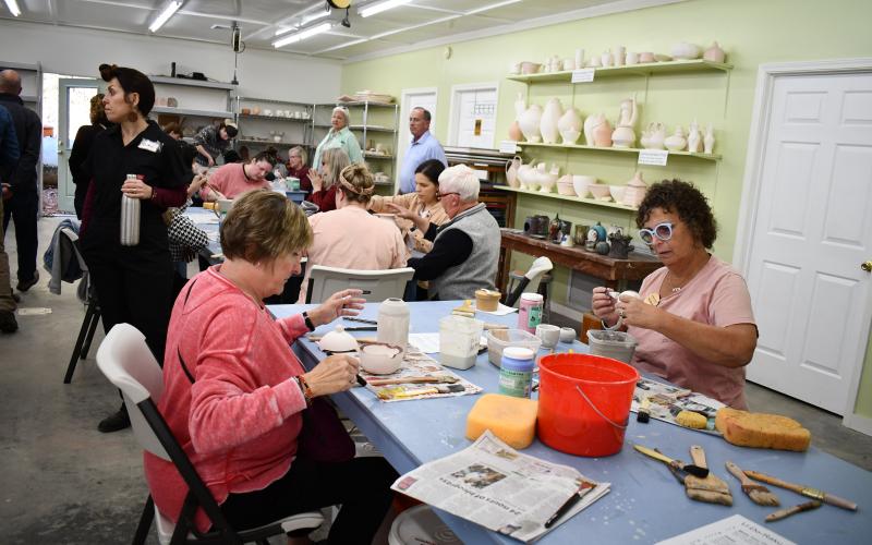 Megan Horn/The Clayton Tribune. Community members complete a U-Do-Raku activity during the Hambidge Center Antinori Open House Nov. 4. Left: Photo courtesy Forward Rabun/Rabun County Chamber of Commerce. Forward Rabun/Rabun County Chamber of Commerce congratulated the Hambidge Center on their ribbon cutting.