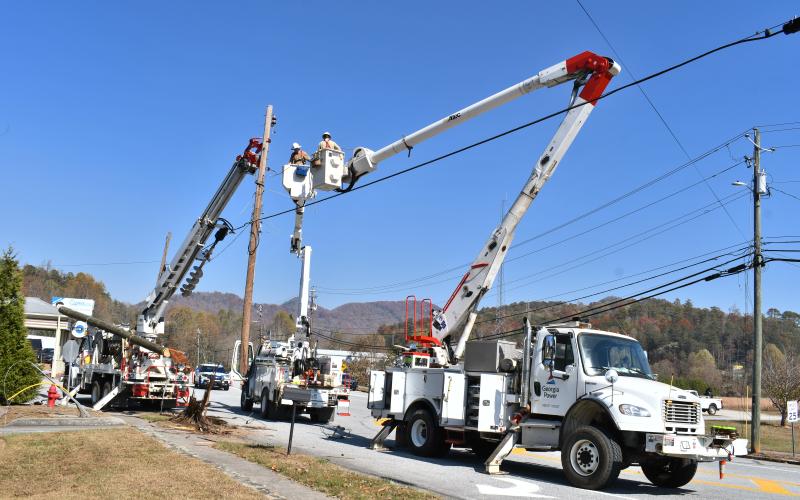 Megan Horn/The Clayton Tribune. Georgia Power crews work in bucket trucks to replace a power pole Tuesday that was completely knocked down due to a one-vehicle crash on North Main Street at Paris Street.