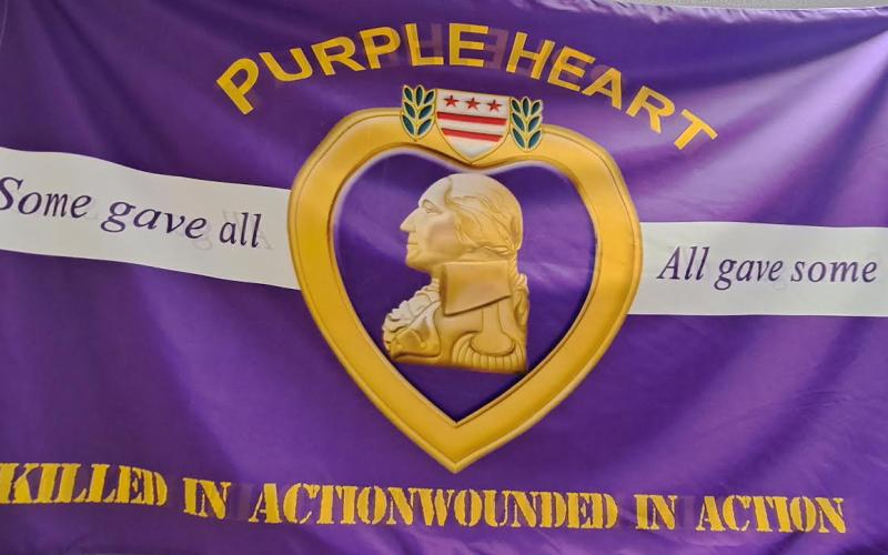 Megan Horn/The Clayton Tribune. The City of Sky Valley has been proclaimed ‘A Purple Heart City’ and displays this purple/gold flag at City Hall.