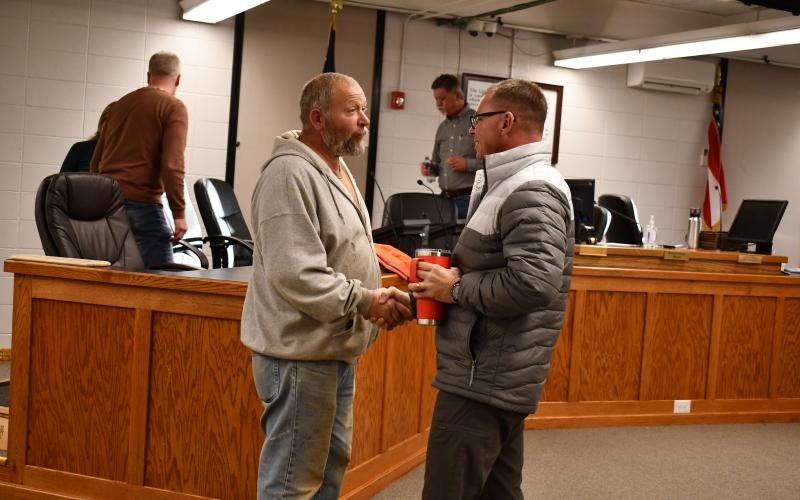 Megan Horn/The Clayton Tribune. Outgoing Clayton council member David Cross shakes hands with incoming council member Stacy Fountain during a special reception Tuesday thanking council members Woody Blalock, John Bradshaw and Cross for their years of service to the city.