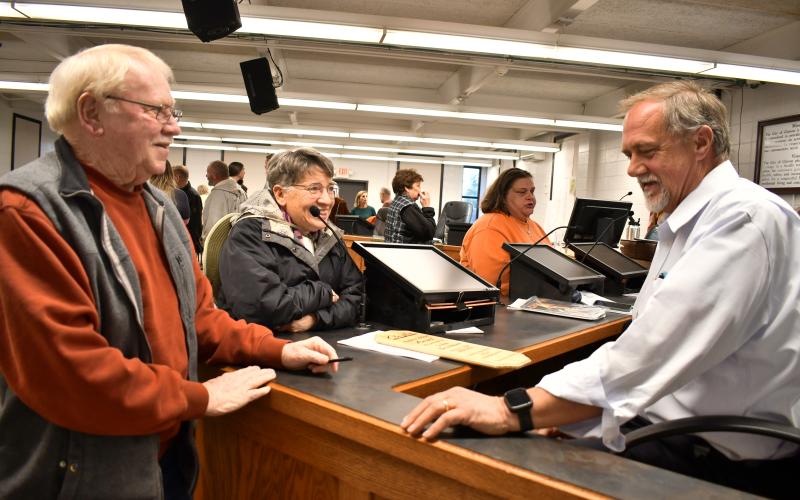 Megan Horn/The Clayton Tribune. Outgoing council member John Bradshaw converses with incoming councilman Tony Allen and Dee Daley on Tuesday.