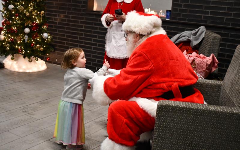 Megan Horn/The Clayton Tribune. 2-year-old Sydney Green and mom Ashleigh Green wave at Santa during the Mountain Lakes Medical Center meet-and-greet event Dec. 14.