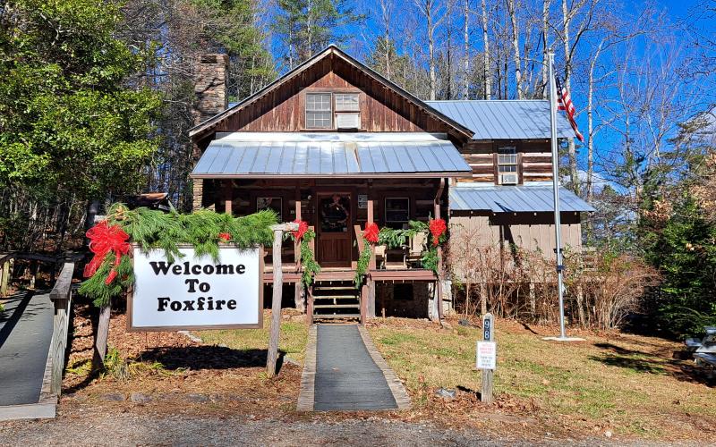 Megan Horn/The Clayton Tribune. The front entrance to Foxfire at 98 Foxfire Lane in Mountain City is decorated with garland and seasonal red bows. On Saturday, Dec. 16, the location will showcase several holiday-oriented Appalachian aspects.