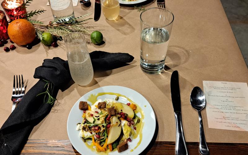 Megan Horn/The Clayton Tribune. The five-course meal began with a warm winter squash and arugula salad with absinthe and rum vinaigrette served with sparkling Cremant de Brut.
