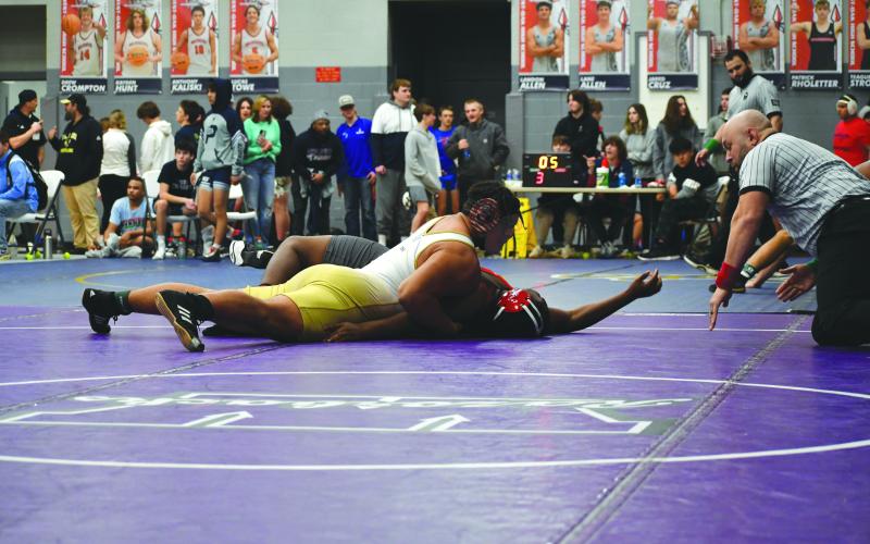 Wade Cheek/The Clayton Tribune. RGNS senior wrestler and football player Kaleb McKenzie pins his opponent to advance to the quarterfinal-round of the 285-pound weight class during Rabun Gap’s tournament at West Oak High School.