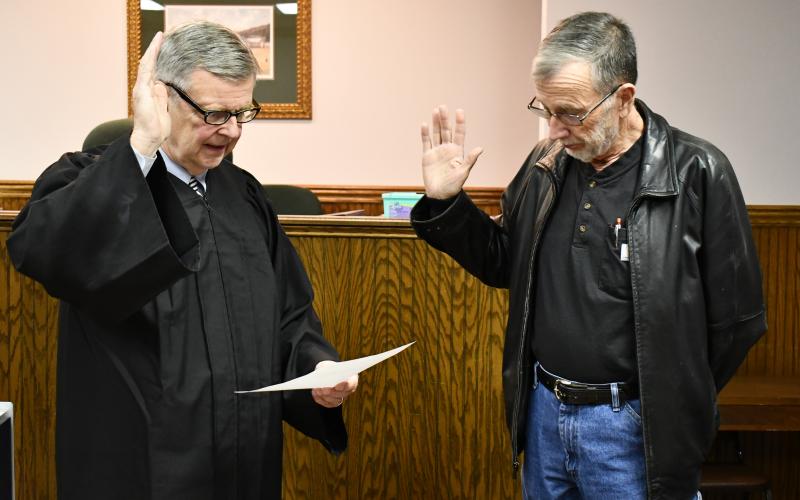 Megan Horn/The Clayton Tribune. Probate Judge Carlton Hobie Jones, III swears in Board Chairman Roy Lovell.