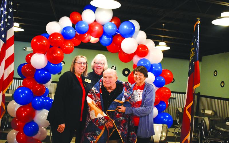 Megan Horn/The Clayton Tribune. Causey is awarded a Quilt of Valor from the Quilts of Valor Foundation by State Coordinator Karen Trombley, Sharon Ruth and Terry Wright.