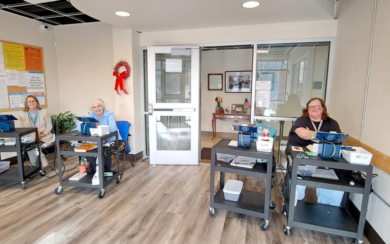 Megan Horn/The Clayton Tribune. Rabun County Elections Office Poll Workers Hollie Greene, left, Ann D’Agostino and Amanda Burrell check in voters casting their ballots during Advanced Voting for the Presidential Preference Primary Tuesday. Early voting continues until Friday, March 8.