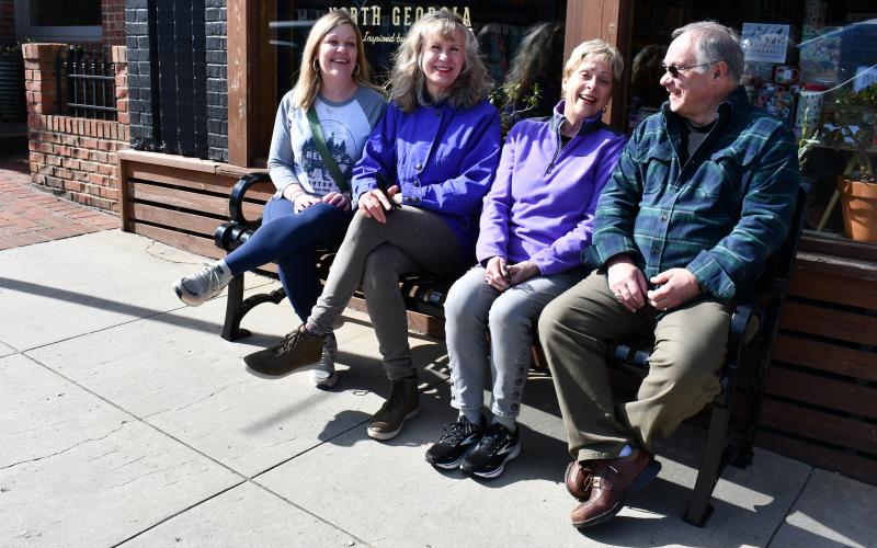 Megan Horn/The Clayton Tribune. DDA members Sonya Shook, Co-Chair Karen Bacon, Chair Cassandra Clouser and Chester Baumgartner enjoy conversing on one of the convenient new benches located on Main Street in downtown Clayton. There are now a total of seven benches in the downtown area. Not pictured are fellow DDA members Trey Sanders and Althea Bleckley.