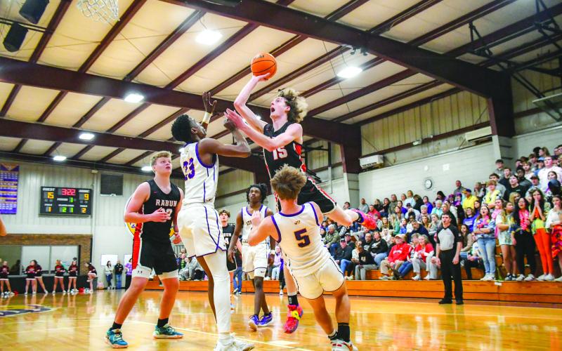 Wade Cheek/The Clayton Tribune. Wildcat basketball sophomore Hayes Free elevates over multiple Athens Christian defenders, drawing a foul, during the Feb. 16 Region 8 championship game. The Wildcats fell to the region champ Eagles.