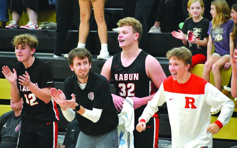 Wade Cheek/The Clayton Tribune. RCHS head boys basketball coach David Adcock cheers on his Wildcats as his players Reed Burrell, Jack Hood and Colton Crane cheer on their teammates during a big performance against Commerce.