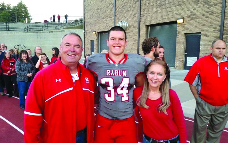 Photo courtesy of Woerner family. Charlie Woerner (center) stands with his mother Kathie Woerner and his father Kent Woerner during a Rabun County football game.