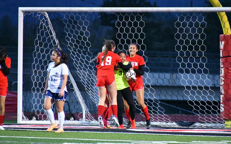 Wade Cheek/The Clayton Tribune. RCHS girl soccer players celebrate with Lady Cat goalkeeper Alesia Gonzalez after she earned a save against Elbert County on Wednesday, Feb. 28. The Lady Cats won 8-1 for their second-straight region win.