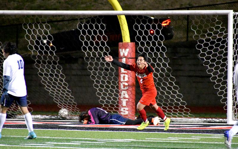 Wade Cheek/The Clayton Tribune. RCHS soccer junior Enrique Tecu sprints to celebrate with his teammates after netting a goal against Elbert County on Wednesday, Feb. 28. Tecu recorded a hat trick against the visting Blue Devils, helping the Wildcats become 3-0 in region play. Currently, RCHS is ranked No. 5 in the state.