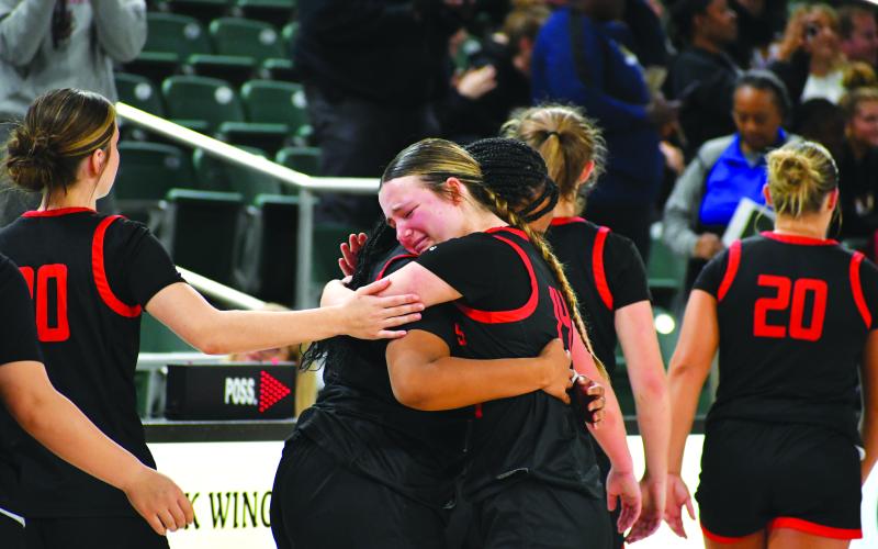 Wade Cheek/The Clayton Tribune. RCHS junior guard Jacie McCall hugs senior Isia Wilmont after the emotional loss to Galloway on March 1 that eliminated the Lady Cat basketball team from the state tournament.
