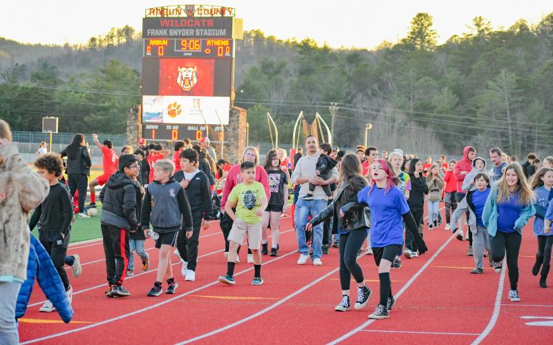 Wade Cheek/The Clayton Tribune. Youth Rabun County soccer players walk the track of Frank Snyder Memorial Stadium on Tuesday, March 19, as the RCHS soccer teams honored the county’s recreation teams between the boys and girls games against Athens Christian.