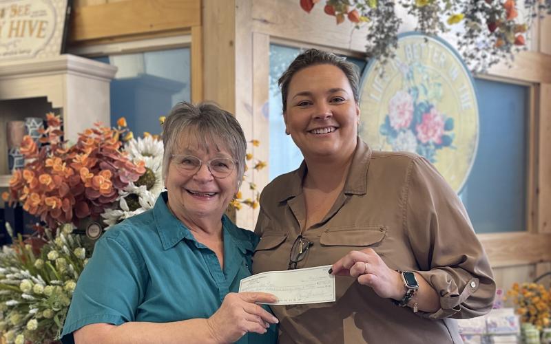 Submitted photo. Clayton Cafe Owner Bonnie Edmonds presents the donation check from the Feb. 19 Spaghetti Dinner ‘Raise a Fork for a Great Causes’ at Clayton Cafe &amp; Market to Rabun Paws 4 Life Fundraising Chair Ara Joyce. The event raised $4,221 for the nonprofit.