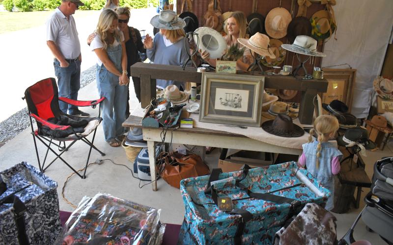 Enoch Autry/The Clayton Tribune. On a sunny day at the Of These Mountains event in Clayton, hat shopping is a must at the Rabun County Civic Center pavilions.
