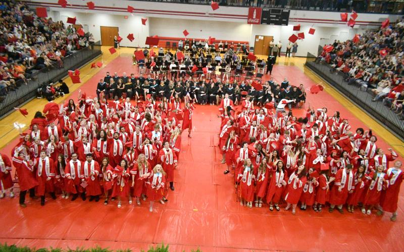 Wade Cheek/The Clayton Tribune. The members of the Class of 2024 from Rabun County High School toss their caps into the air inside the campus gym upon graduation.
