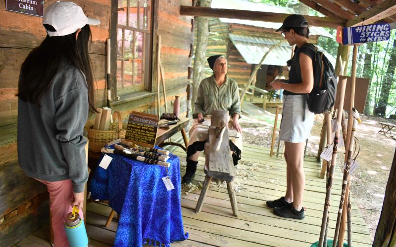 Megan Horn/The Clayton Tribune. Demonstrator Isabel King at Foxfire Heritage Days last weekend speaks to event-goers Constanza Urresty and Eleonora Olguin about her Walking Sticks and Talking Sticks. Most Native American gatherings were held in a circle and the Talking Stick was passed around to each person. The person with the stick had their turn to speak.
