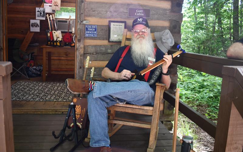 Megan Horn/The Clayton Tribune. Les Barnett demonstrates his hand-made instruments at Gott Cabin during Foxfire Heritage Days in Mountain City June 7 and 8.