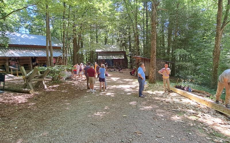 Megan Horn/The Clayton Tribune. Event-goers to the Foxfire Heritage Days event last weekend watch as Ben Banick demonstrates hewing logs. The June 7 and 8 event in Mountain City marked the 50th anniversary of the start of the Foxfire Museum.