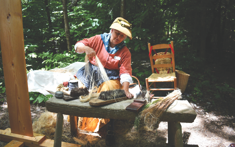 Megan Horn/The Clayton Tribune. Flax demonstrator Carol Salloum with the group “Southeastern Civilian Living Historians” demonstrates how Flax seed becomes linen during Foxfire Heritage Days.