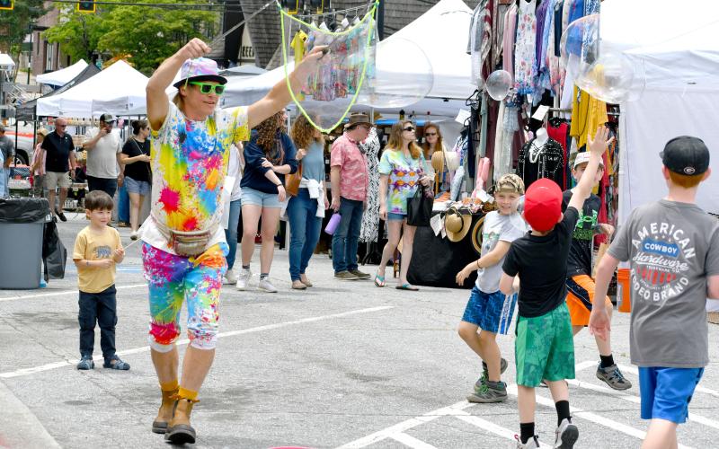 Wade Cheek/The Clayton Tribune. Local man Tyler Ratcliffe also know as the “Bubble Man” creates massive bubbles as children attempt to pop them at the City of Clayton’s inaugural Ramshackle event on Saturday, June 1. Ratcliffe was surrounded by a large number of vendors and tents for local businesses that were set up on Main Street.