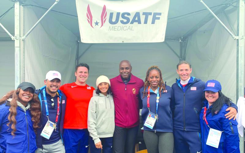 Submitted. Ena Weinstein (fourth from left) stands for a photo with former world-class Olympian and track star Carl Lewis (center) and other Team USA staff members during the 2023 Pan American Games in Chile.
