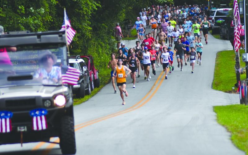 Enoch Autry/The Clayton Tribune. Eventual 5K winner Luke Napier leads the 909 participants at the beginning of the July 6 Rabun Ramble on Lake Rabun Road. The annual Independence Day event has its largest-ever turnout.