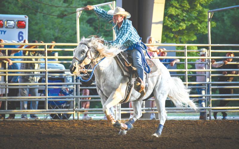 Wade Cheek/The Clayton Tribune. Calf roper Cliff Hammond and his horse glide forward during the calf roping event at this past weekend’s Bar W Rodeo that was at Rabun Arena from Friday, July 5, to Saturday, July 6.