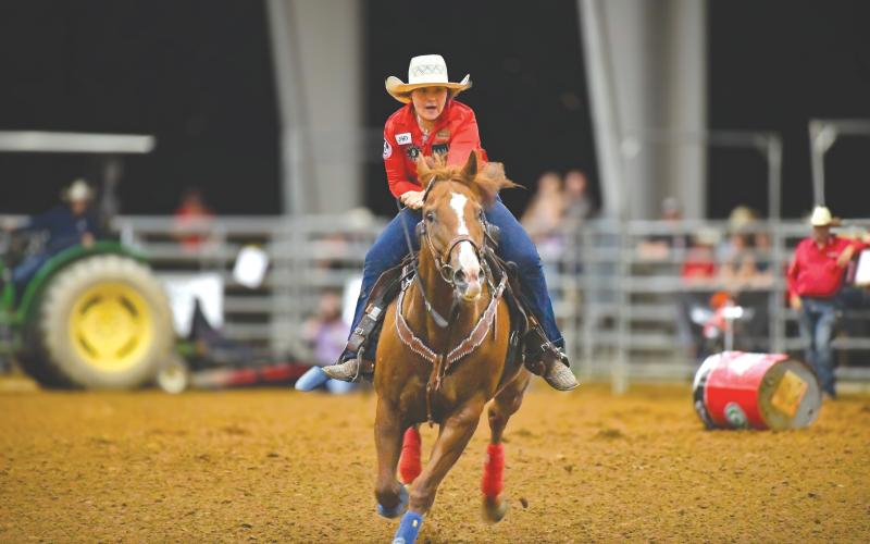 Wade Cheek/The Clayton Tribune. Barrel racer Kayla Earnhardt navigates the arena doing her best to complete her round without a knocked barrel. Earnhardt finished sixth in the event.