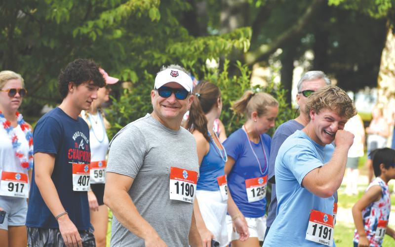 Wade Cheek/The Clayton Tribune. Rabun County Administrator Darrin Giles (1190) and his son Jarret Giles, a recent Rabun County High School graduate (far right), have a good time at last weekend’s Lake Burton Fun Run on Saturday, July 6.
