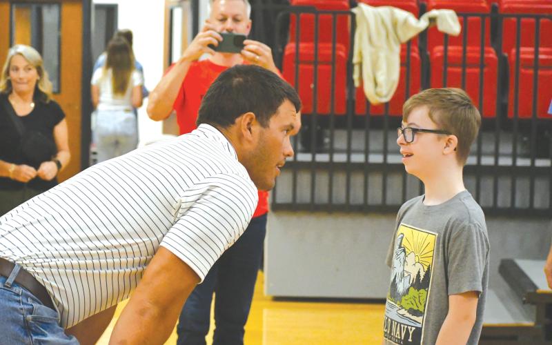 Wade Cheek/The Clayton Tribune. Former RCHS football star and current Atlanta Falcon Charlie Woerner shares a moment with Asher Thurmond at the Night of Champions that was held at the RCHS gym.