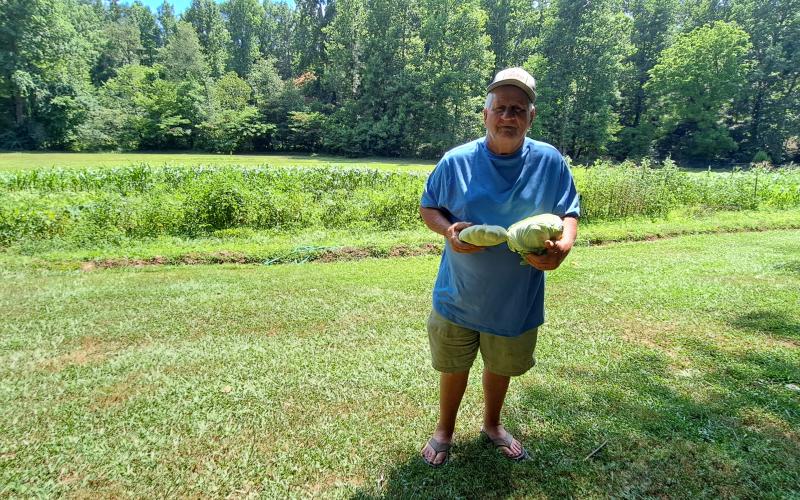 Megan Horn/The Clayton Tribune. Joey Davenport displays some of the vegetables he grew out of his local garden.