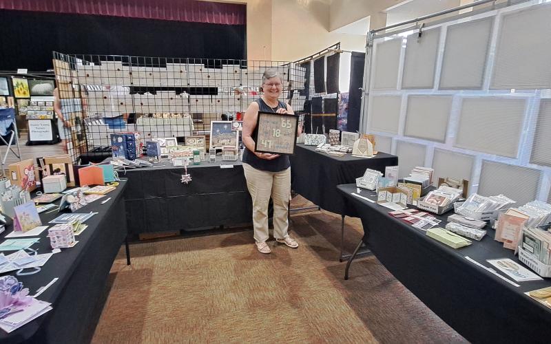Megan Horn/The Clayton Tribune. Maria Childers makes beautiful, unique and intricate greeting cards for every occasion as well as other paper artwork. She displayed her work during the 2024 Painted Fern Art Festival last weekend. Below: Submitted. At the 2024 Painted Fern Art Festival, Sean and Ebony Wilson (left) were the Producers’ Choice Award winners for Best Booth with their woodworking. Sharon Mumbi (right) was chosen by show visitors and awarded the Peoples’ Choice for Best in Show.