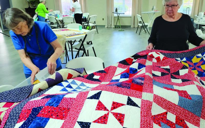 Submitted photo. Suzanne Dover and Frieda Payne add the finishing touches to their quilts during the “Quilt-a-thon” April 18-20 with the Northeast Georgia Chapter of Quilts of Valor. Below: Jeanie Whitworth makes a red, white and blue quilt during the “Quilt-a-thon” April 18-20 with the Northeast Georgia Chapter of Quilts of Valor.