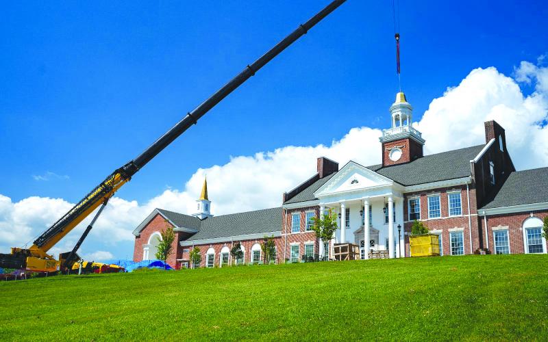 Submitted photo. Crews from Carroll Daniel Construction work to place the iconic Cupola back atop Hodgson Hall.