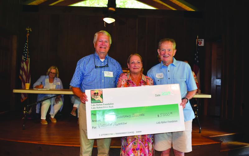 Submitted photo. Steve Raeber and Buz Stone present Victoria Anderson with the Buz Stone Award and $5,000 grant from the Lake Rabun Foundation.