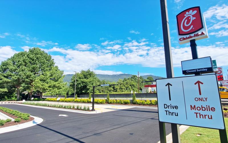 Megan Horn/The Clayton Tribune.  Customers can utilize the left lane for traditional drive-thru only and the right lane for orders taken on the Chick-fil-A mobile app only. Visitors must be in their respective lanes in order to obtain their orders. Below: Those who order from the Chick-fil-A mobile app can go through the right “mobile-thru” lane at the restaurant and scan a QR code to obtain their order.