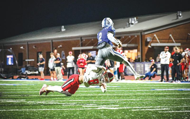Wade Cheek/The Clayton Tribune. Freshman Colter Cannon completes a tackle amid a hurdling Lawson Sullivan on Friday, Aug. 23, against Fannin County.