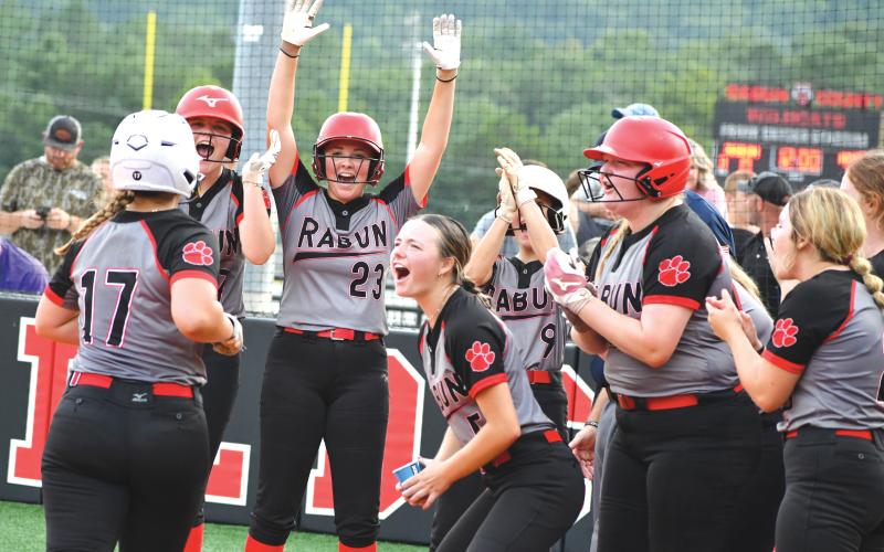 Wade Cheek/The Clayton Tribune. RCHS softball freshman River Evans touches home plate and celebrates with her Lady Cat teammates after she cracked a grand slam during Rabun’s home game against Lumpkin County on Thursday, Aug. 1. The Lady Cats fell to the Indians 15-11 while also falling to Towns County 11-10 on Monday, Aug. 5.