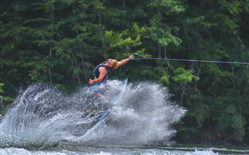 Wade Cheek/The Clayton Tribune. Chase Andrews, an original founder of the Mountain Air Classic, flies backward through the wakes of Lake Burton during his strong run at the 24th running of the lake event. Andrews and 34 other competitors did their best wakeboarding last weekend on Saturday, Aug, 3.