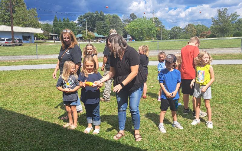Megan Horn/The Clayton Tribune. Many families at last weekend’s Tiger Corn Festival enjoyed participating in a non-walking cakewalk where they passed the plush candy corn around to music. When the music stopped the person holding the candy corn won a delicious cake. Pictured in the forefront are Zailynn Whitmire; Stephanie Watts; Journi Whitmire; Gypsy Hamby; Ashley Whitmire, who won that cake walk; Jaxon Watts; and Ruby Whitmire.