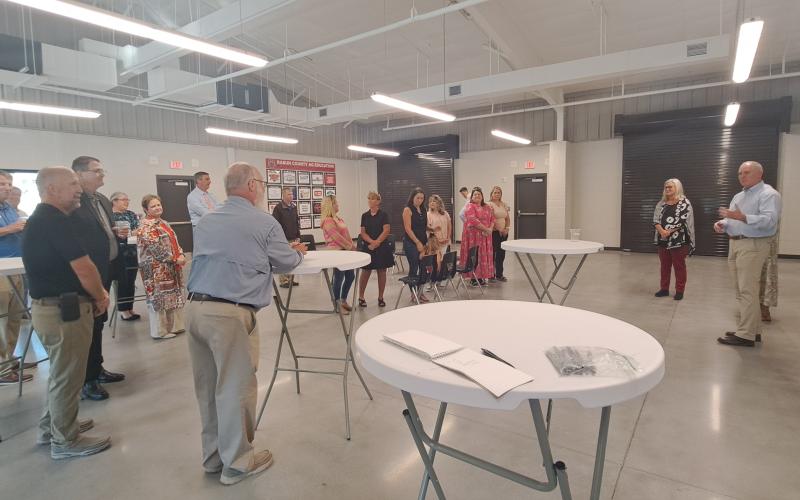 Megan Horn/The Clayton Tribune. Rabun County Board of Education Member Rick Story, right, gives kind remarks during a reception at the Agricenter Tuesday thanking Superintendent Dr. April Childers for her service and leadership to the school system. School officials, community leaders and board of education members attended the reception honoring Childers. Below: Rabun County Schools Superintendent Dr. April Childers converses with Mickey Duvall during her reception.