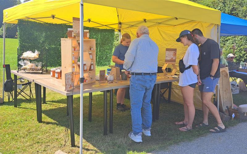 Megan Horn/The Clayton Tribune. Chloe McCrackin, 11,  talks to event-goers at the Tiger Corn Festival last Saturday. She said she started beekeeping at the age of 9 with her uncle and father and found a passion for it. McCrackin said her favorite part about beekeeping is spending time with her father.
