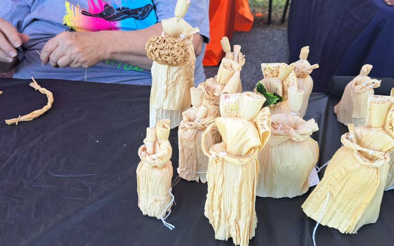 Megan Horn/The Clayton Tribune. Paulette Carpenter creates Corn Husk dolls in the “primitive style” during last weekend’s Tiger Corn Festival. She said she has been making them for over 60 years and is something she did as a child.