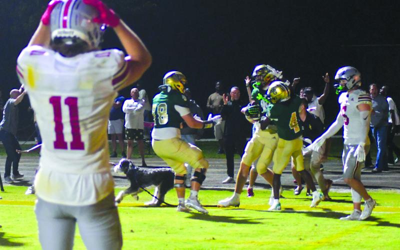 Enoch Autry/The Clayton Tribune. The Hun School’s Bryce Kania (11), a Wake Forest commit, reacts to Rabun Gap’s senior tight end Marshall Pritchett receiving congratulations in the end zone by teammates junior wide receiver CJ Willingham (4), and senior guard and Georgia Tech-commit Justin Hasenhuetl (78) after the North Carolina commit catches a touchdown pass at the end of regulation against Raiders senior free safety and Stanford-commit Liam Thorpe (5).