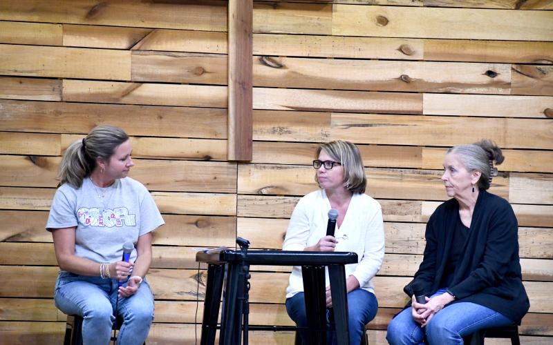 Megan Horn/The Clayton Tribune. Elizabeth Adams, executive director of Place of Hope North Georgia, left, has a heartfelt interview and discussion with long-time Rabun County foster moms Linda Ramey, center, and Linda Loudermilk for the keynote event at the Picnic for a Purpose fundraiser. Below:  Each table at the event was decorated in Major League Baseball memorabilia to go with the theme of the evening.