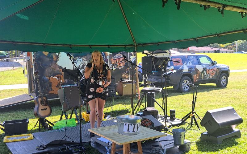 Megan Horn/The Clayton Tribune. Gina Cowart performs live music during last weekend’s festival and begins the music for the day. She also sang the National Anthem at the opening festivities.